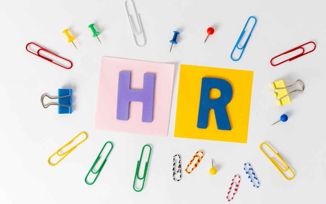 Das Bild zeigt die Buchstaben HR, gebastelt aus buntem Papier, mit bunten Büroklammern drum herum